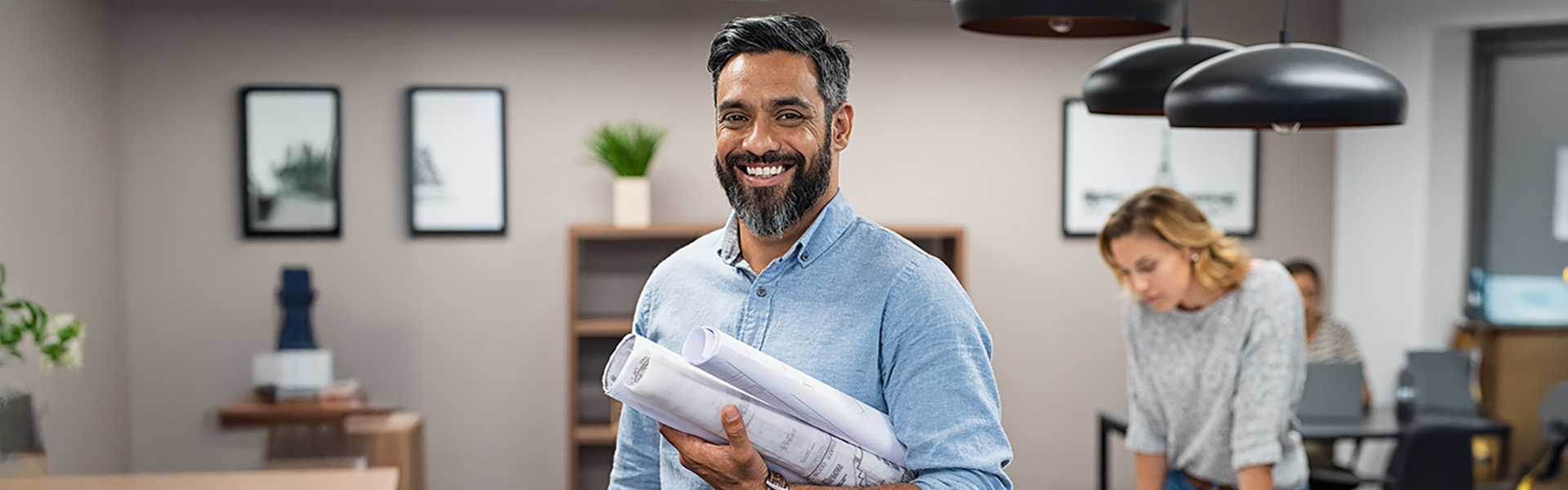 Happy latin architect holding blueprints