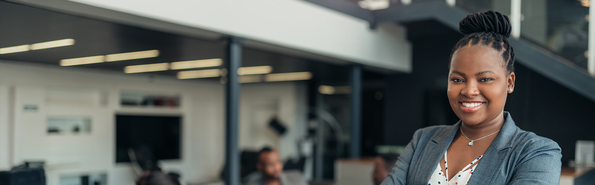 Portrait of a confident black businesswoman with all African American team in the background