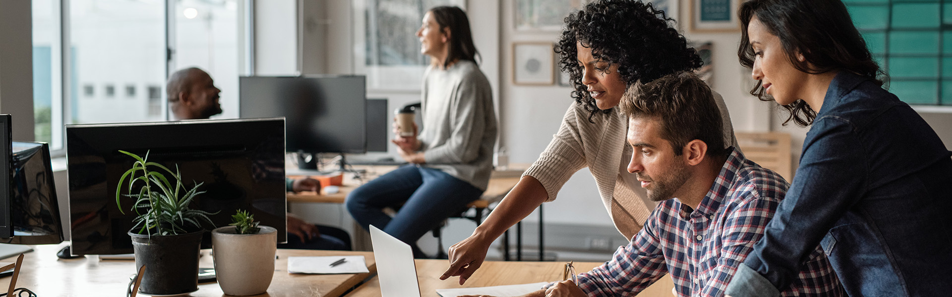 Black woman in office, smiling and looking at camera