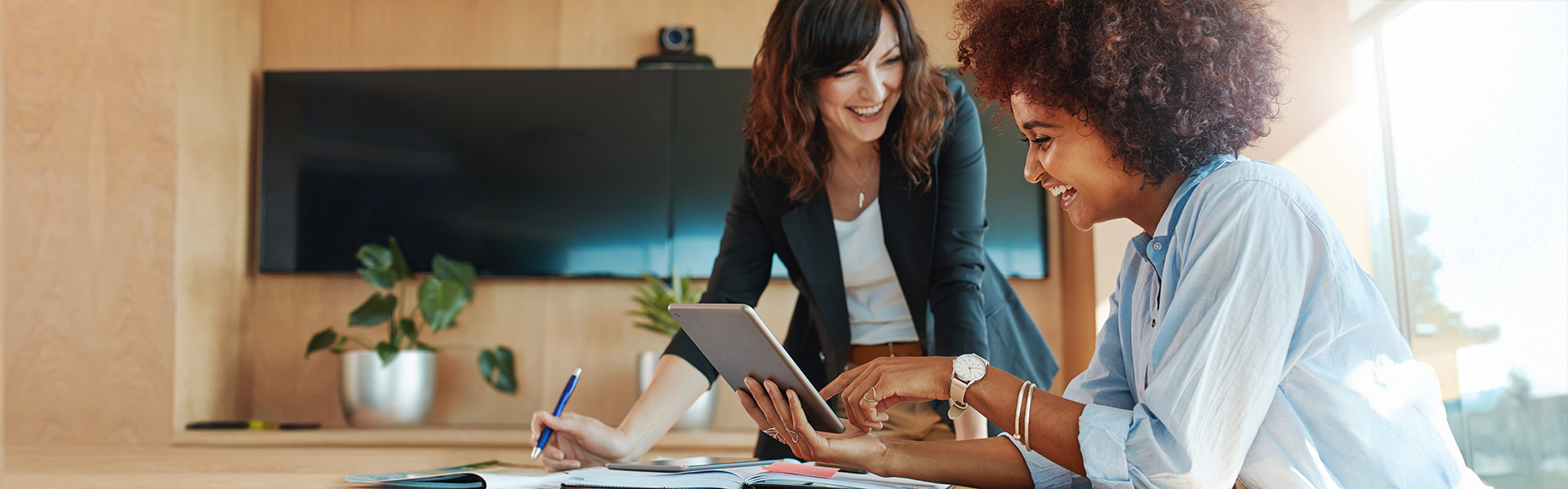 Two business women using digital tablet in office