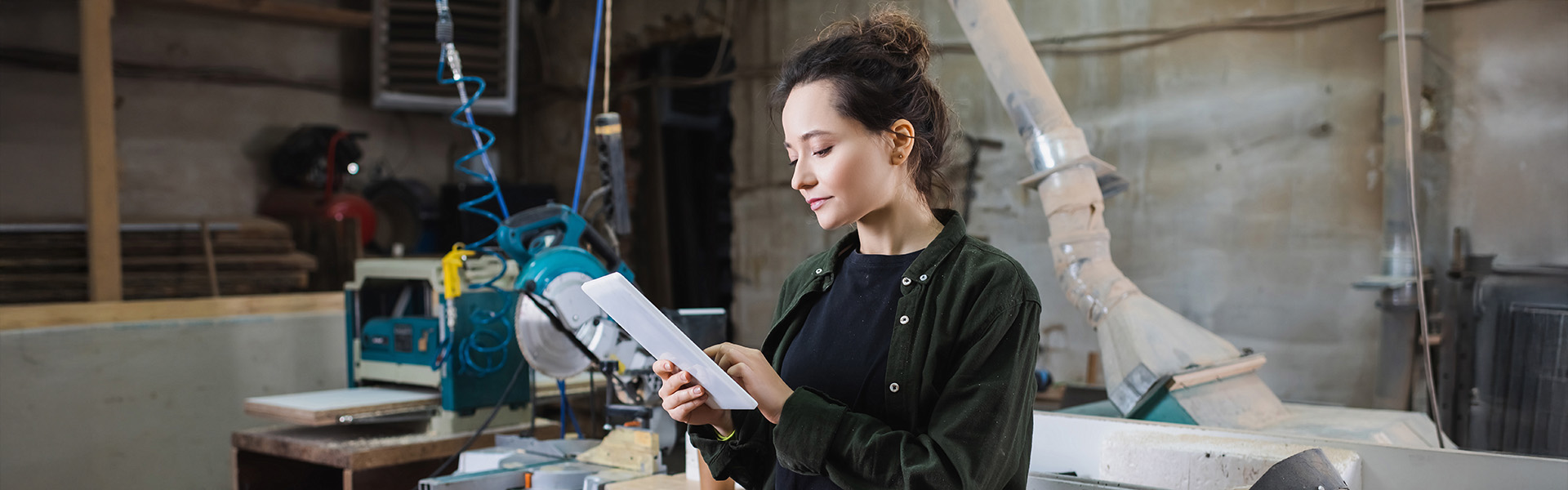 Young carpenter using digital tablet in workshop
