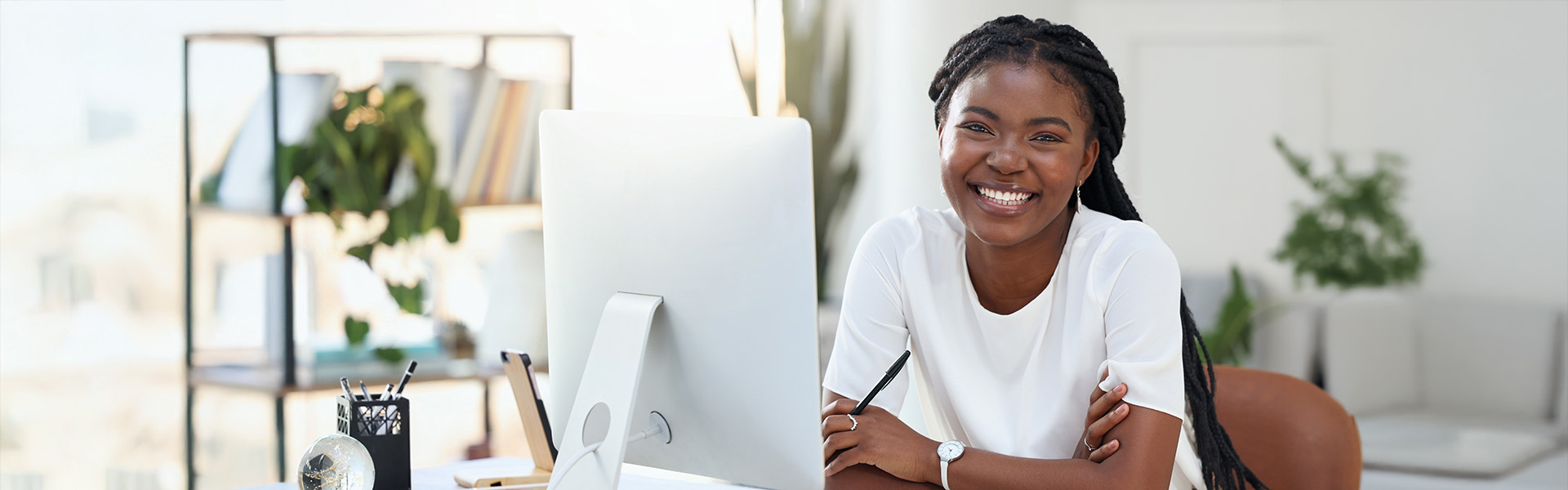 Portrait of black woman in office at a desk with computer